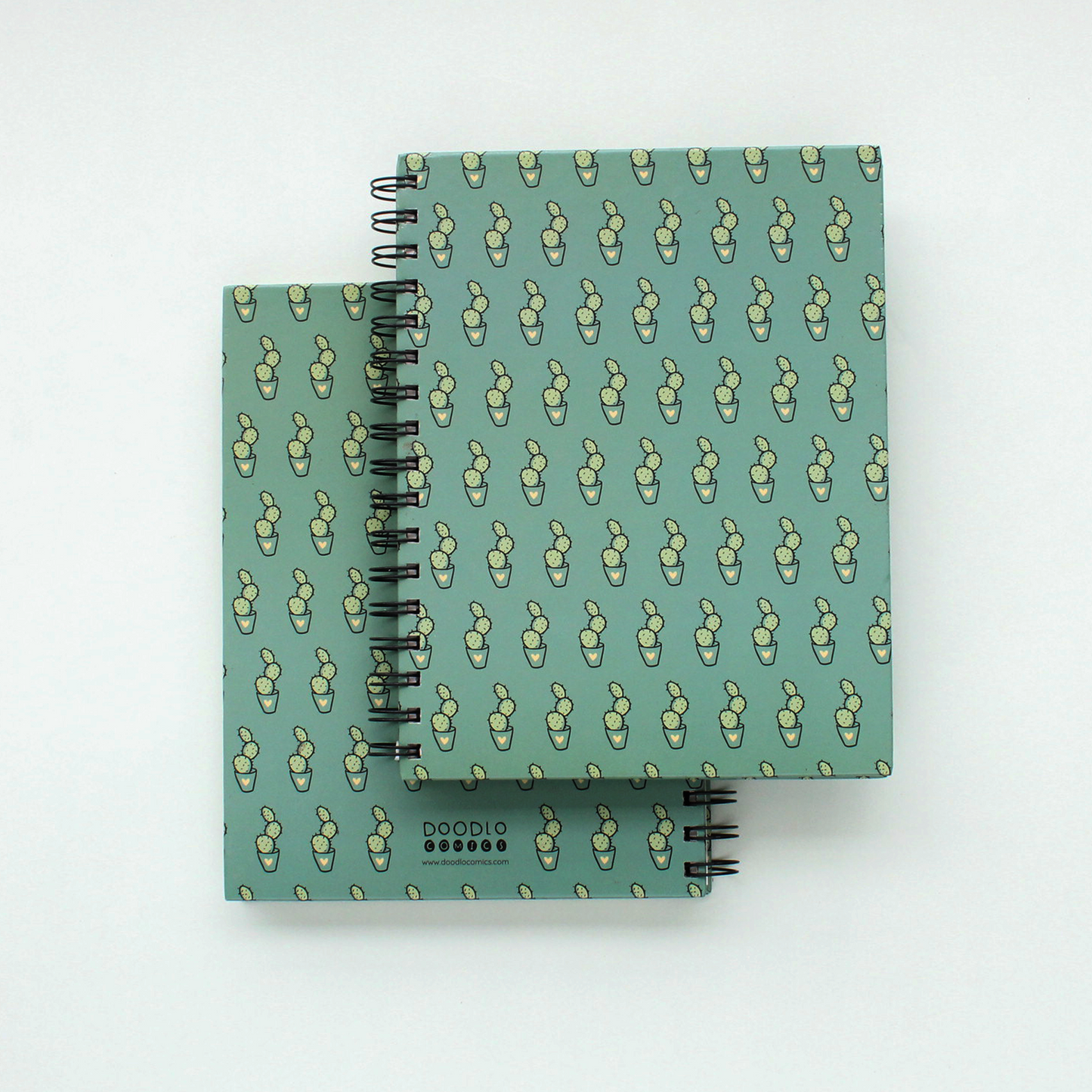 two spiral notebook of cactus doodle stacked upon each other